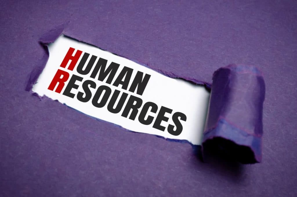 Torn purple paper on white surface with HUMAN RESOURCES word