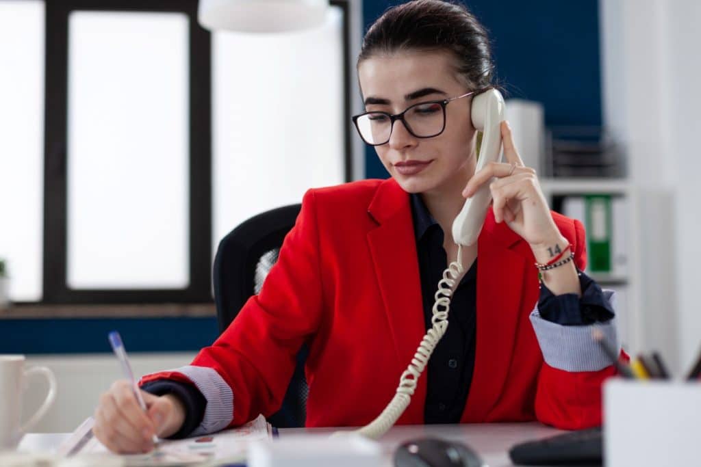 procurement generalist sitting on her desk while on phone